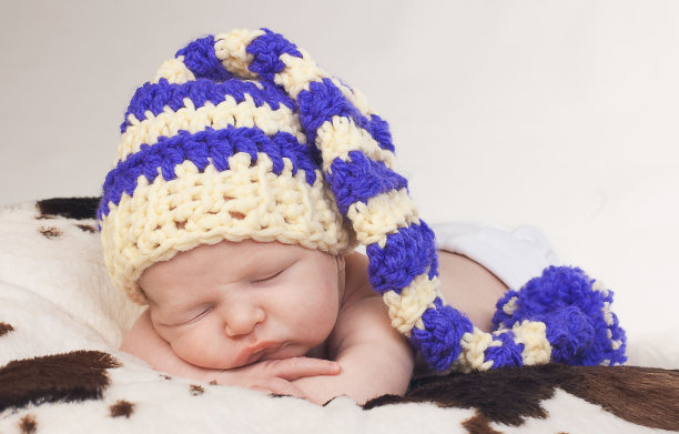 戴着帽子的可爱新生男婴正在睡觉图片下载