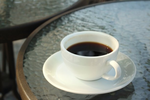 桌上的白杯子里装着咖啡。图片下载