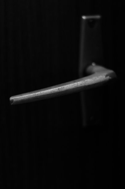 破旧、旧的金属门把手。黑色和白色。图片下载