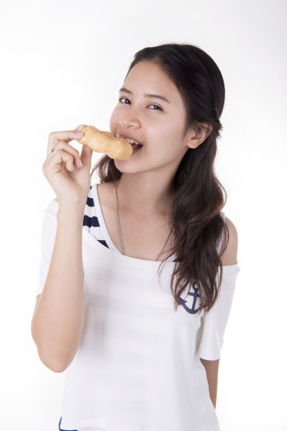 年轻女子正要吃甜甜圈(白色背景)图片下载