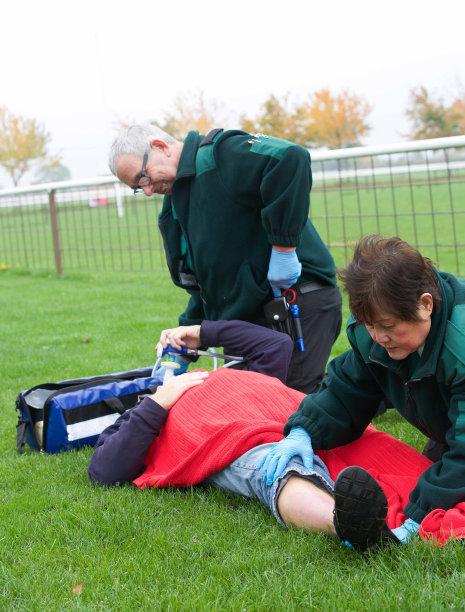 一名腿部受伤的男子瘫倒在地，医护人员在一旁看护图片下载