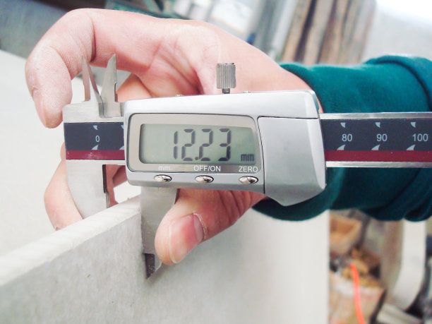 工人测量板厚水平以保证质量图片下载