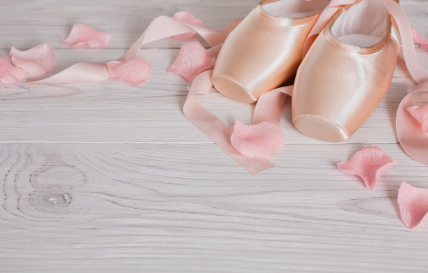 粉红色芭蕾舞尖头鞋在白色的木头背景图片下载