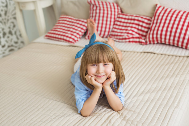 一个可爱的小女孩躺在床上图片下载