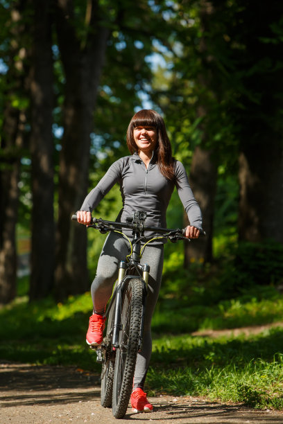 骑自行车的女人在公园里骑自行车图片下载