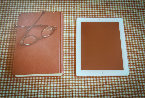 复古色调，桌子上放着旧书、智能手机和眼镜图片下载