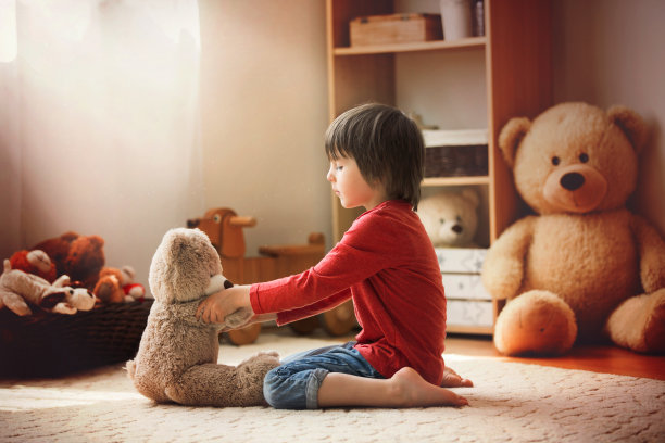 可爱的小孩，学前班的小男孩，在玩泰迪熊图片下载