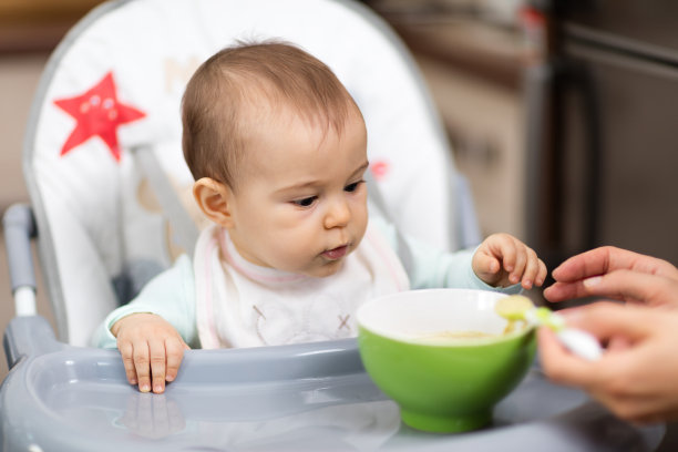 美丽的小女孩在吃她的第一顿饭素材图片