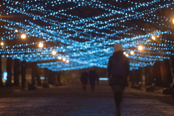 灯火通明的节日小巷上人们的剪影图片下载