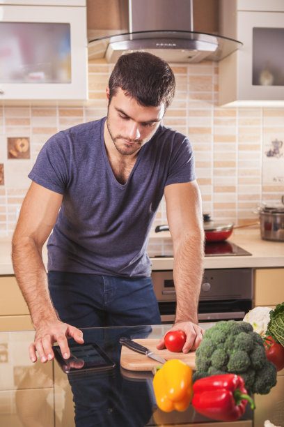 一个在平板电脑上找食谱的帅哥图片下载