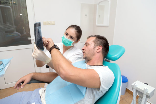 年轻的病人和牙医给他看x光照片图片下载