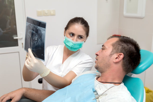 年轻的病人和牙医给他看x光照片图片下载