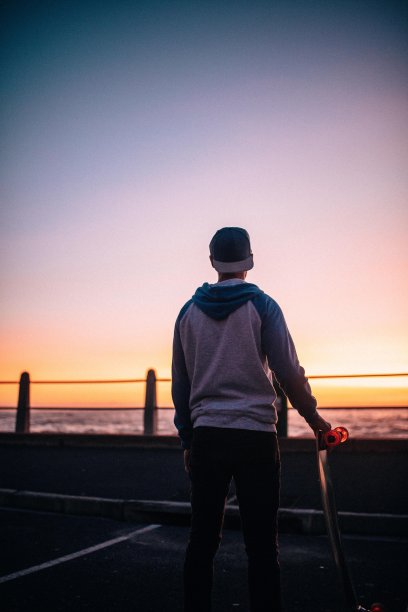 一个穿着长板站在路上的嬉皮士图片下载