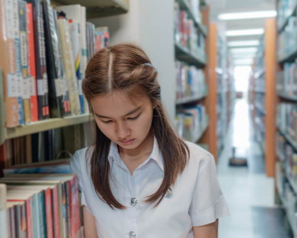 身着制服的泰国女学生在图书馆看书图片下载