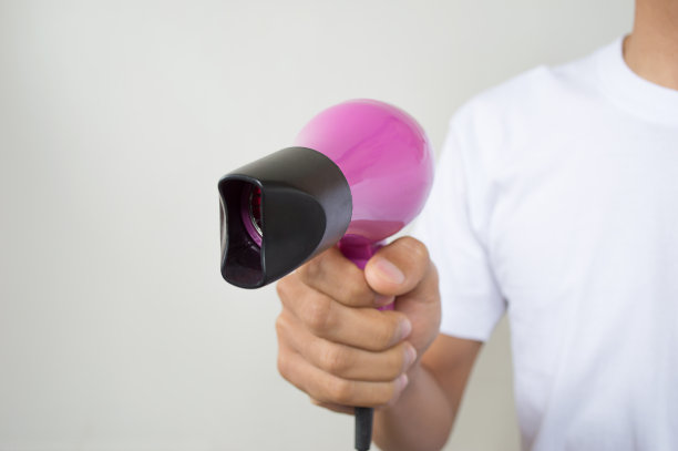 手里拿着小巧的紫色吹风机图片下载