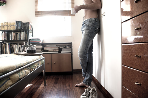 一个男人从卧室的窗户往外看图片下载