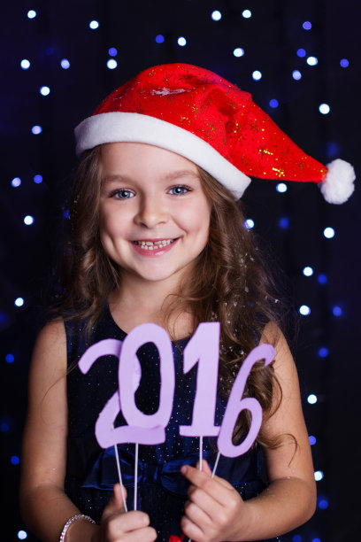圣诞女孩正拿着2016年的纸俑，过圣诞节图片下载