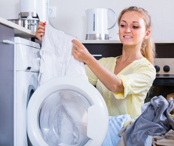 家庭主妇从洗衣机里拿衣服的照片图片下载