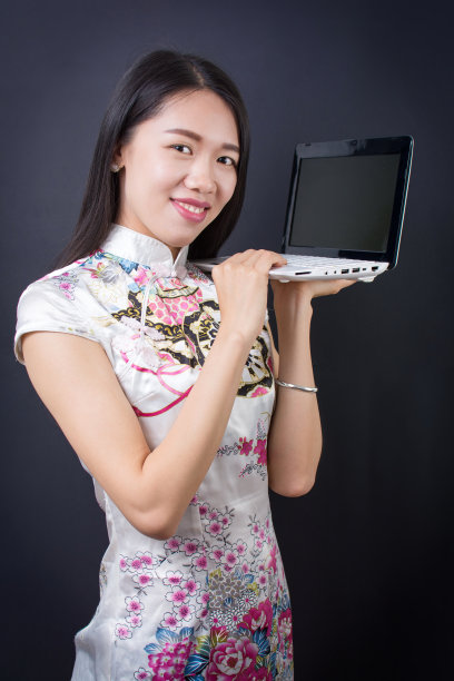 一个年轻的亚洲女人拿着笔记本电脑图片下载