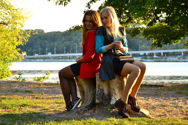 两个女孩背靠背在外面图片下载