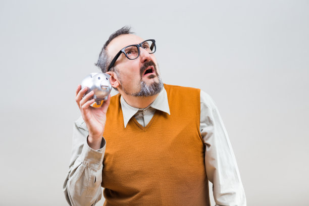 拿着空储蓄罐的书呆子素材图片