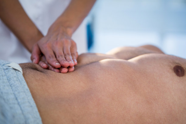 理疗师给一个男人做胃部按摩图片下载