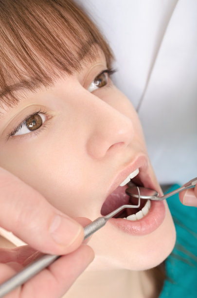 牙医正在治疗一个小女孩的牙齿图片下载