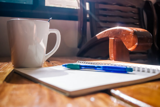 一杯咖啡和一支笔放在笔记本上图片下载