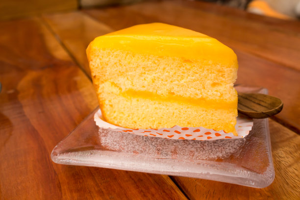 咖啡厅木桌上的橙色蛋糕图片下载