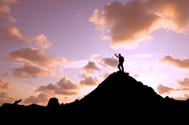 成功登山者的侧影和戏剧性的天空后退图片下载