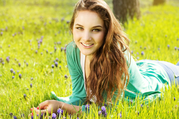 美丽的女孩躺在草地上素材图片
