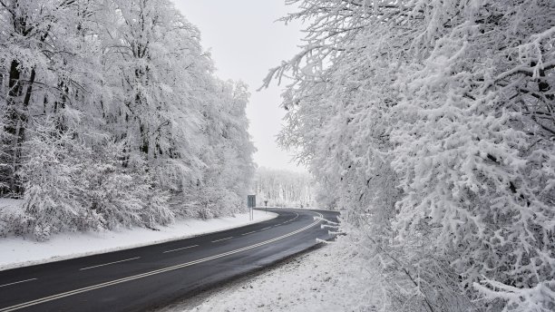 空旷的道路与积雪覆盖的景观。交通和汽车的背景。图片下载
