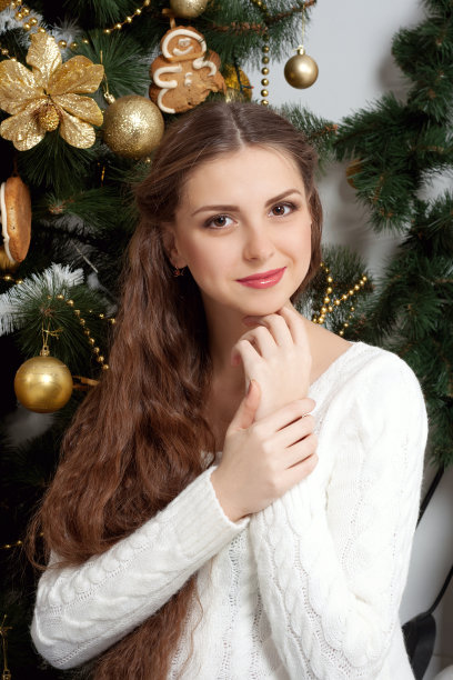 在圣诞树的背景下，一个怀孕的女孩图片下载