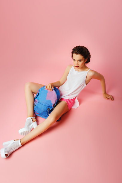 时尚的女人高跟鞋与背包在工作室摆姿势图片下载