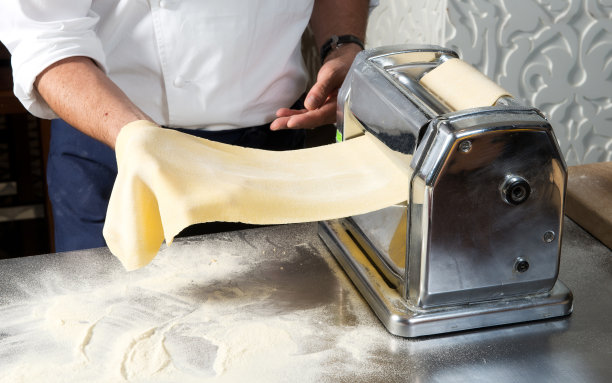 年轻的厨师准备自制的意大利面图片下载