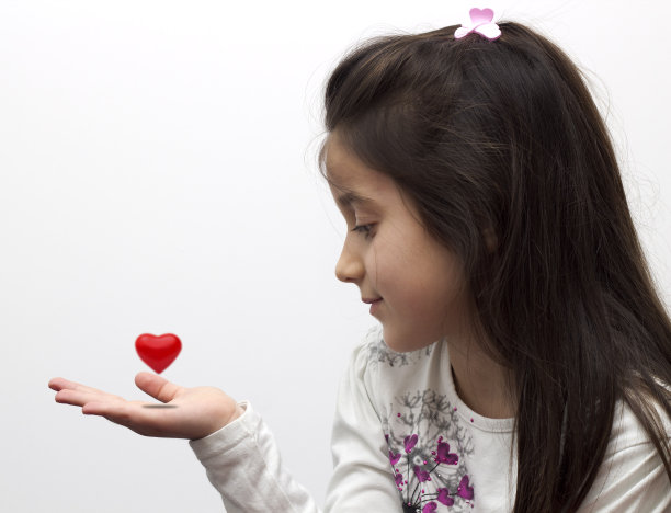 小女孩手里捧着一颗心图片下载