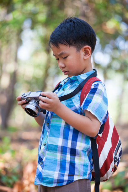 亚洲男孩在数码相机里查看照片。图片下载