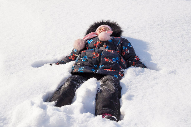 小女孩在清澈的白雪中玩耍图片下载