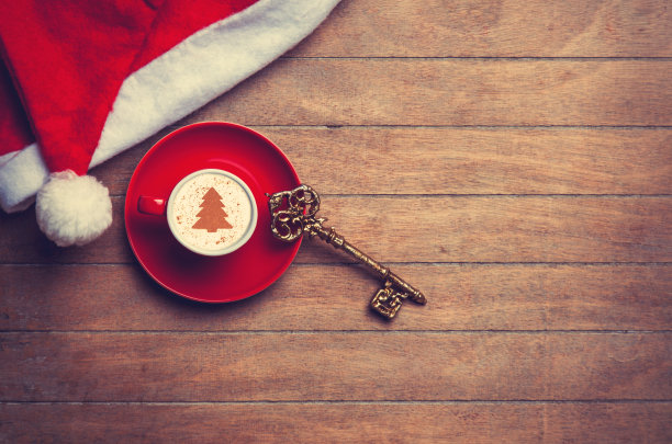 卡布奇诺，帽子和钥匙放在桌子上。图片下载