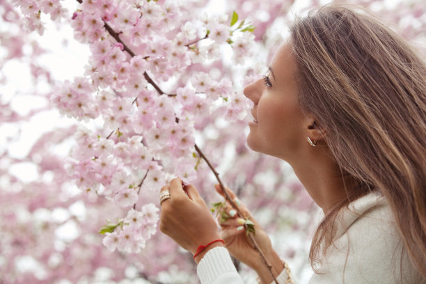 美丽的年轻女子的肖像在开花的春天的花园图片下载