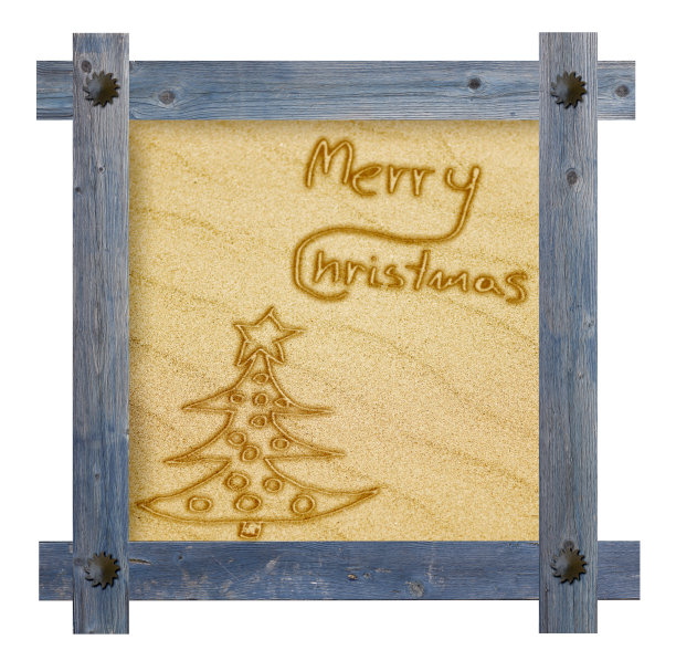 在沙色背景上手写圣诞快乐。木蓝框图片下载