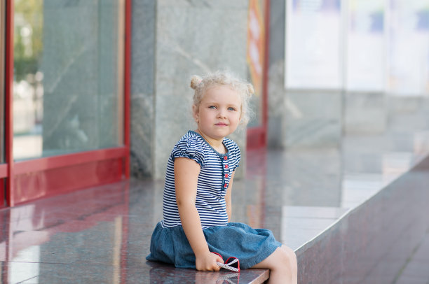 白人女孩坐在店面附近图片下载