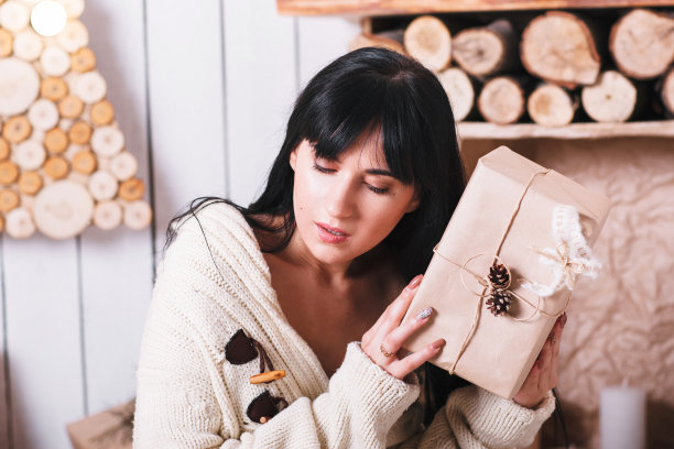 一个细心的女孩，拿着包装好的圣诞礼物图片下载