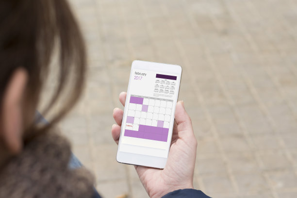 女性手里拿着智能手机。素材图片