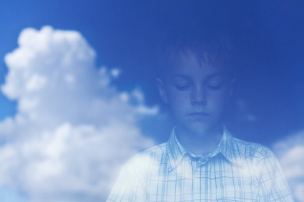 一个男孩的影子和窗玻璃上的云朵。图片下载