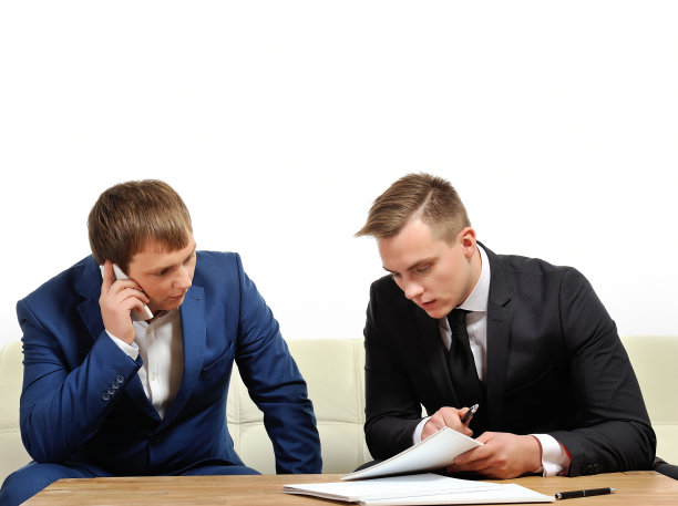 两个商务人员通过电话与合作伙伴分享信息。图片下载