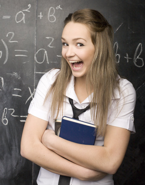 快乐可爱的学生与书在教室里的肖像图片下载