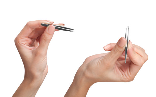 女孩双手拿着两把金属的钢镊子。图片下载