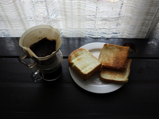 一杯涂了黄油的咖啡吐司放在木桌上图片下载