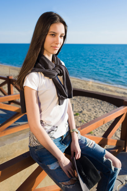 美丽的女人在海边散步后享受休息图片下载